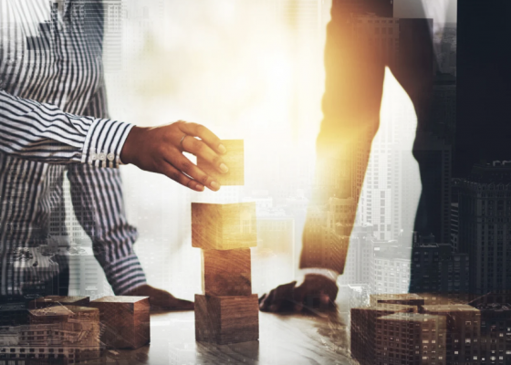 Two people at table with business building blocks planning