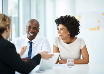 Young couple smiling at a meeting with sales person